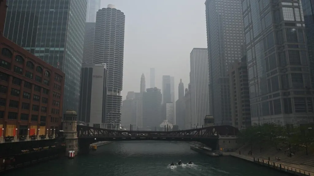 Lo skyline e il fiume di Chicago ridotti a silhouette grigie dalla fitta foschia degli incendi.